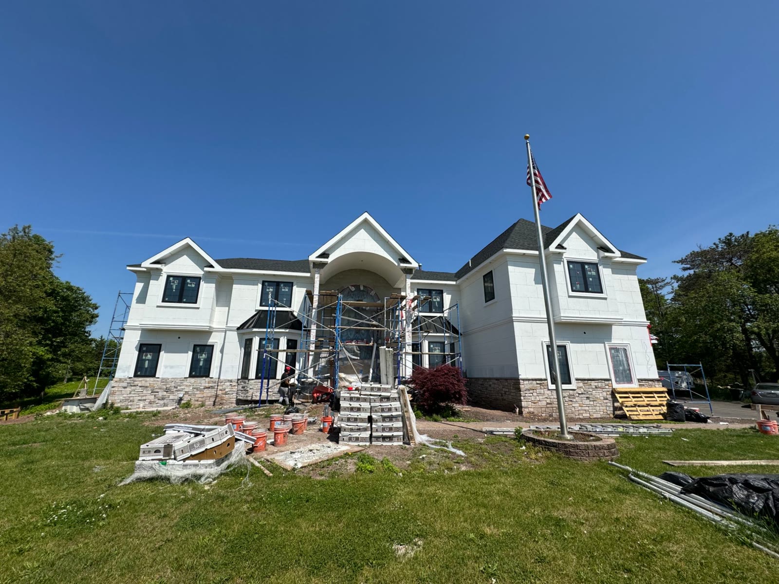 The front of the house during construction, with scaffolding at the arched entry