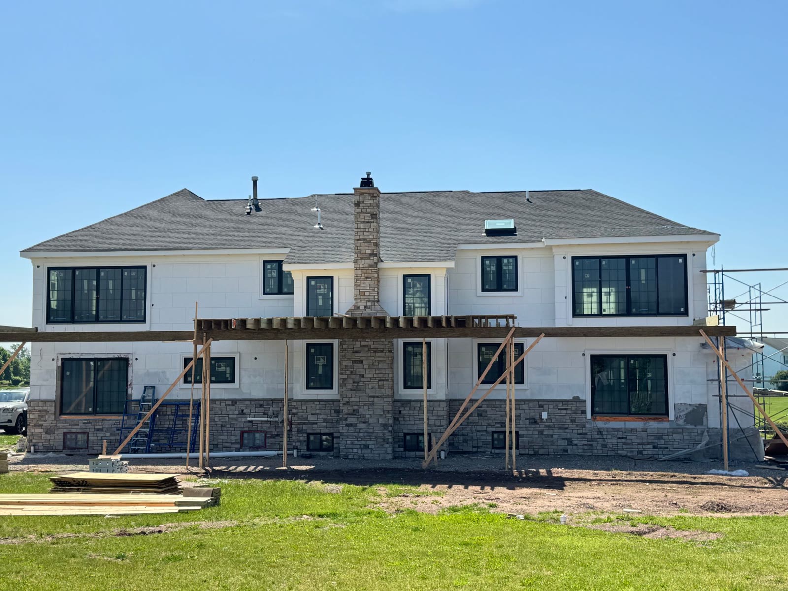 The rear of the house with stone chimney and the deck being framed