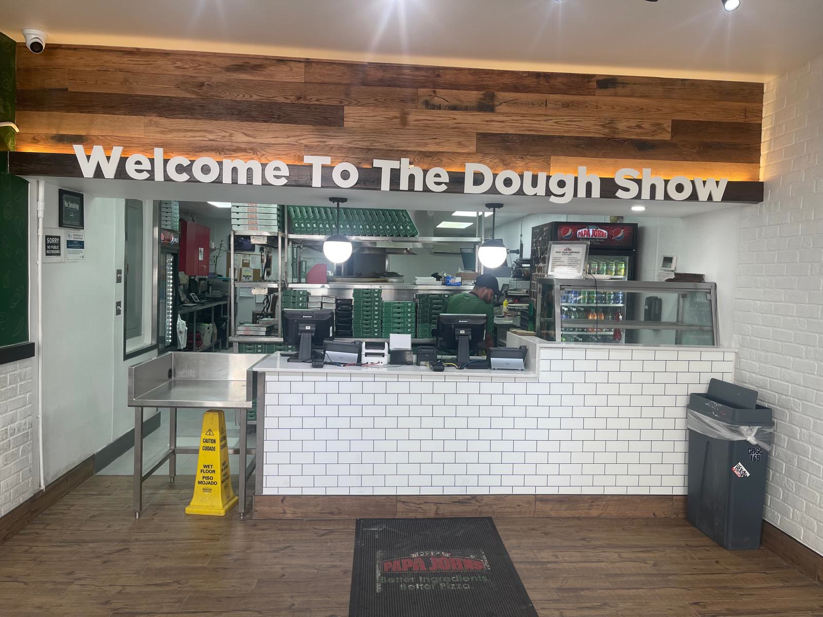Service counter under a reclaimed wood header that reads Welcome To The Dough Show