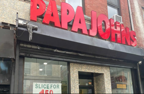 The storefront with red Papa John's letters over the entrance